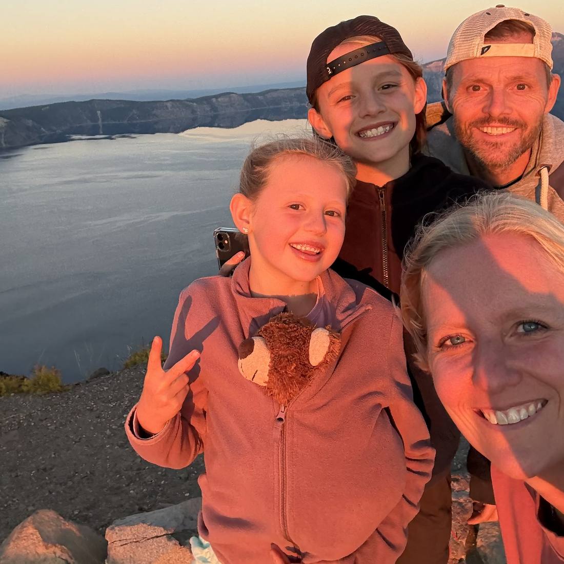 Een gezin bij zonsondergang op de rand van Crater Lake, Oregon, Amerika