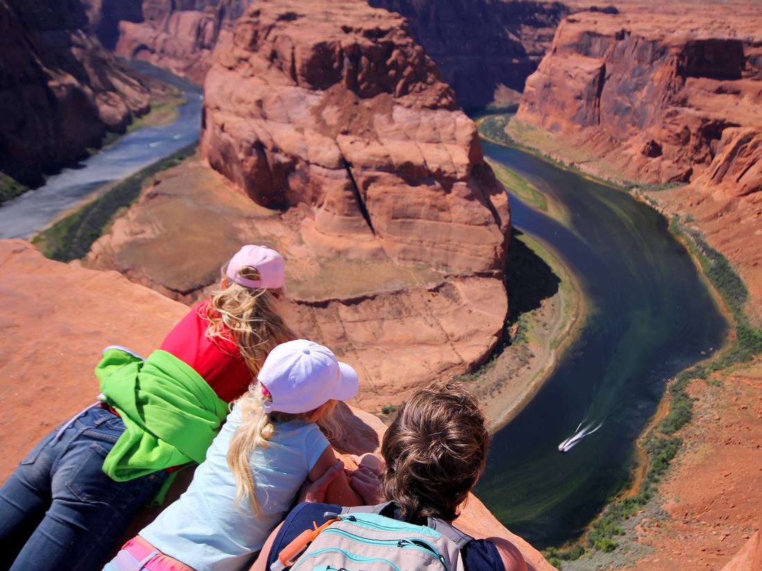 Kinderen kijken over de rand van Horseshoe Bend bij Page, Arizona, Amerika