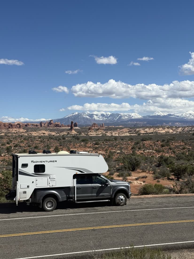 De camper op de weg bij Arches, met de La Sal Mountains erachter, Utah, Amerika