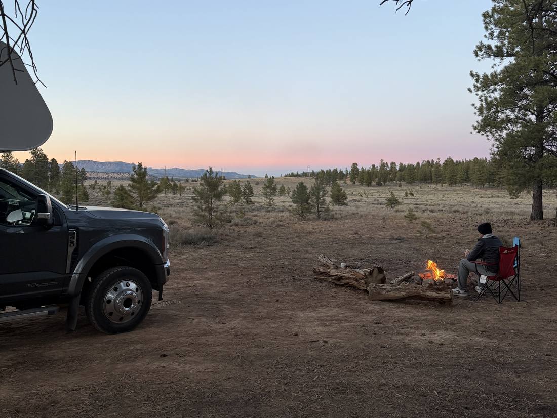 Kampvuur bij de auto op een camping in de schemering, het westen van Amerika