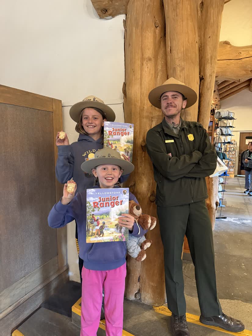 Kinderen krijgen hun Junior Ranger-boekje van een parkranger, het westen van Amerika