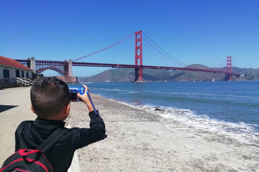 Kind fotografeert de Golden Gate Bridge vanaf het strand, San Francisco, Amerika