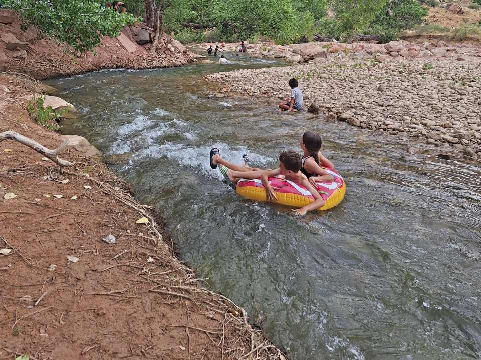 Kinderen drijven op een band de rivier af bij Zion, Utah, Amerika