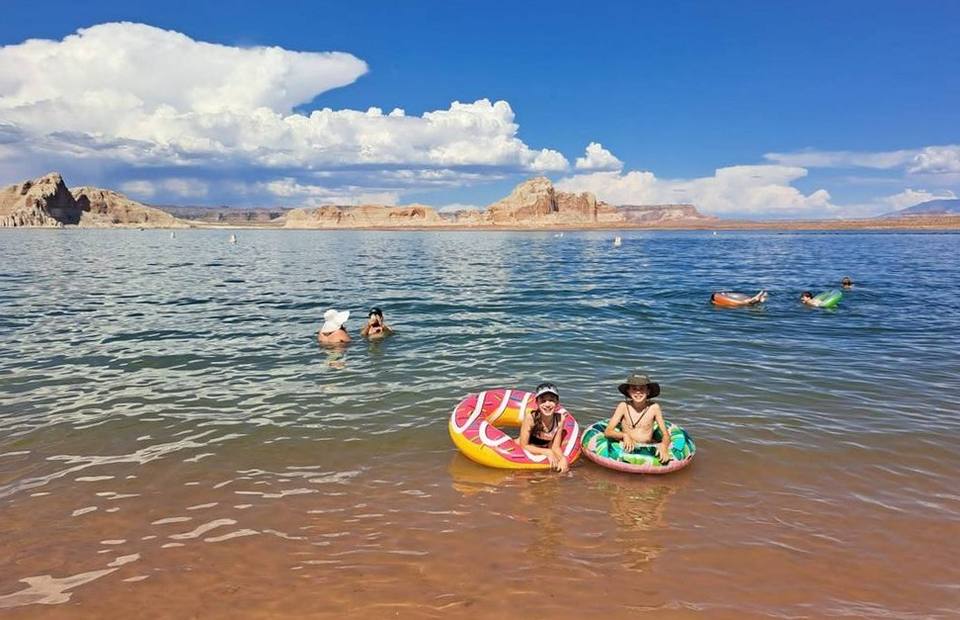 Kinderen dobberen op zwembanden in Lake Powell, Amerika