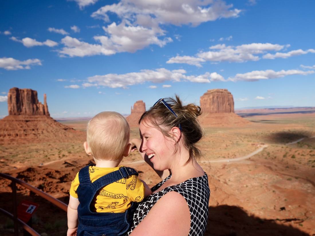Een moeder met een peuter op de arm bij de rotsen van Monument Valley, Utah, Amerika