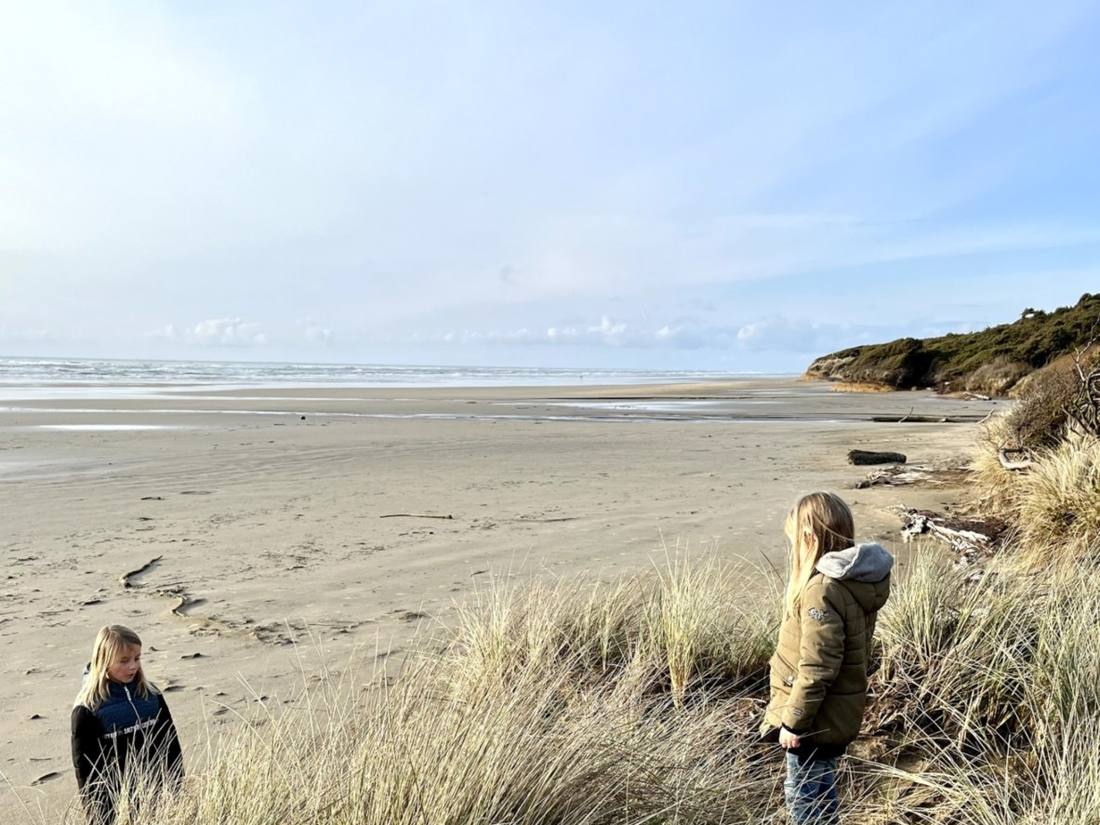 Twee kinderen tussen het helmgras in de duinen aan de kust van Oregon, Amerika