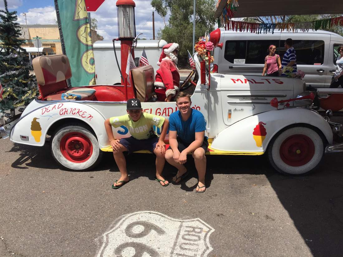 Twee jongens bij een oude auto aan Route 66 in Seligman, Arizona, Amerika