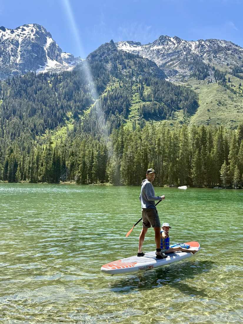 Suppen met een kind op een bergmeer bij Grand Teton, Wyoming, Amerika