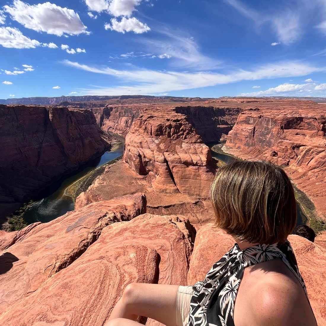 Een vrouw kijkt uit over Horseshoe Bend bij Page, Arizona, Amerika