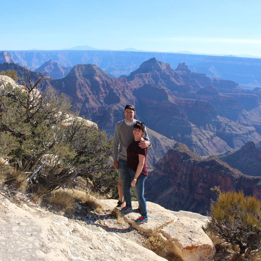 Een stel op een rots aan de rand van de Grand Canyon, Arizona, Amerika