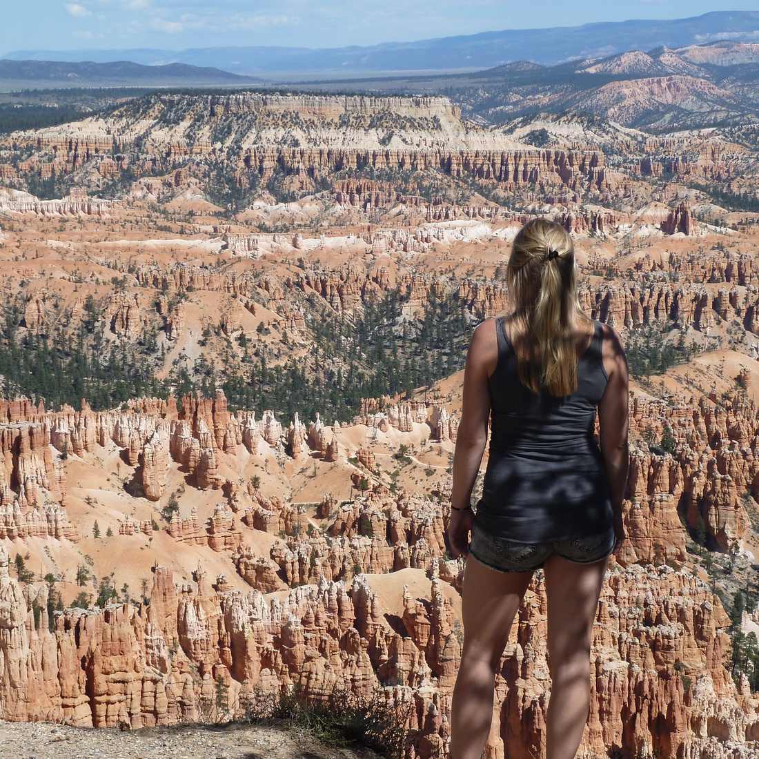 Een vrouw kijkt uit over het amfitheater vol hoodoos van Bryce Canyon, Utah, Amerika
