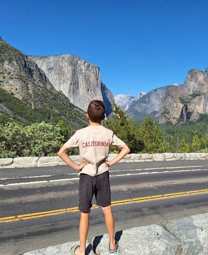 Een jongen in een Californië-shirt kijkt uit over het dal van Yosemite, Californië, Amerika
