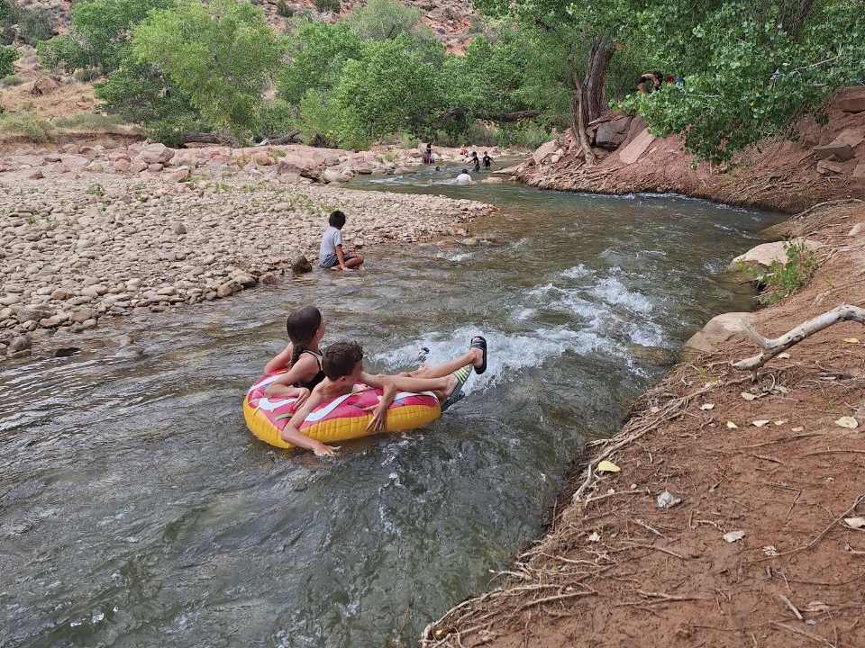 Kinderen drijven op een band de rivier af bij Zion, Utah, Amerika