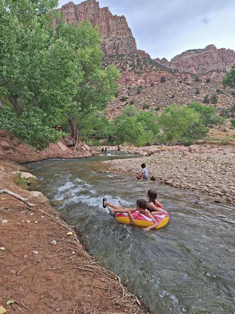Kinderen spelen met een band in het riviertje bij Zion National Park, Utah, Amerika