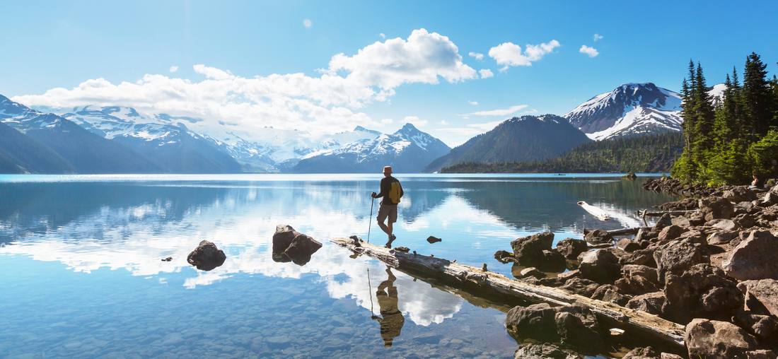 Op een boomstam in een spiegelglad bergmeer in de Rockies, West-Canada