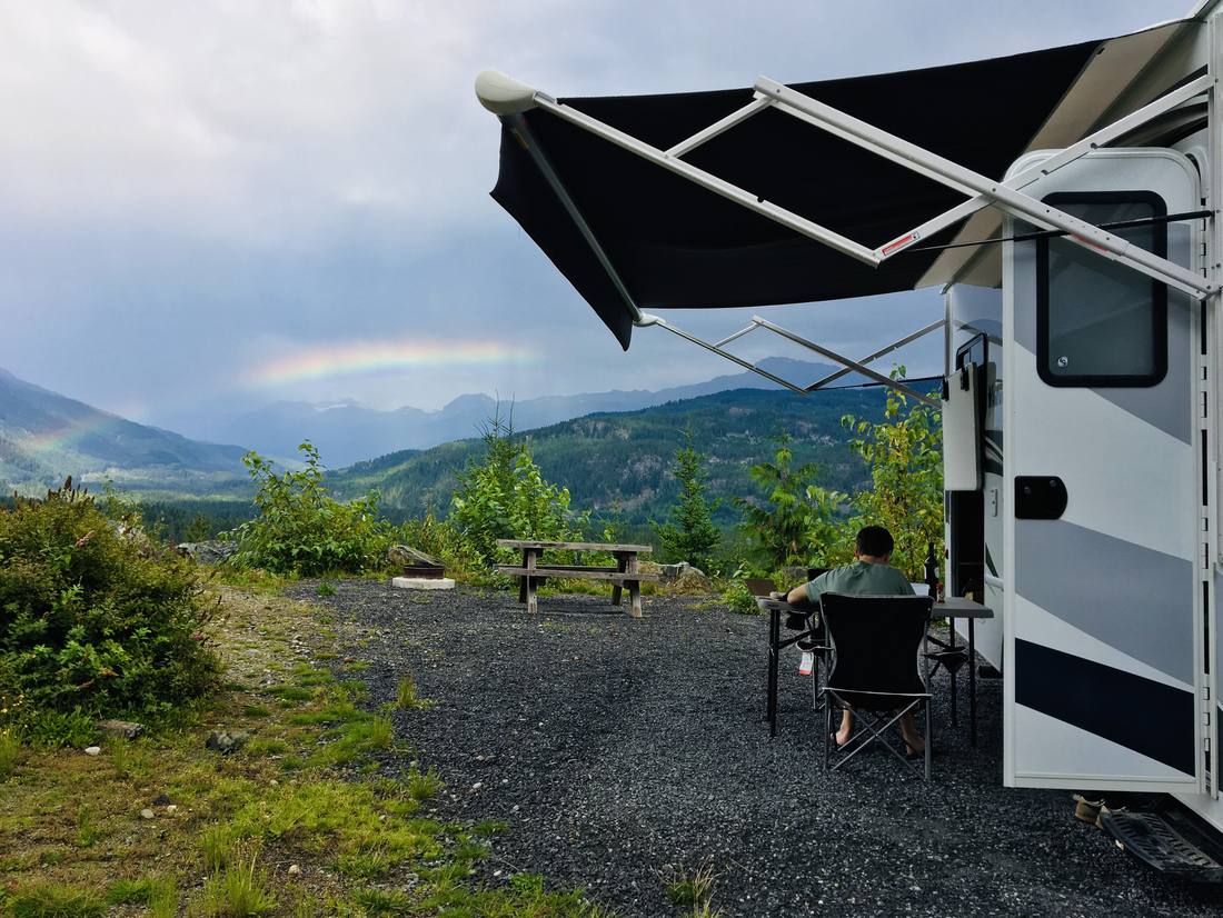 De camper met de luifel uit en uitzicht op de bergen, West-Canada