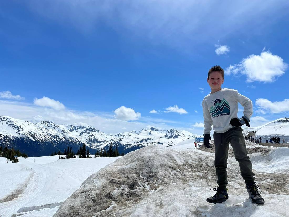 Kind op de sneeuw van de gletsjer, met de bergen erachter, West-Canada