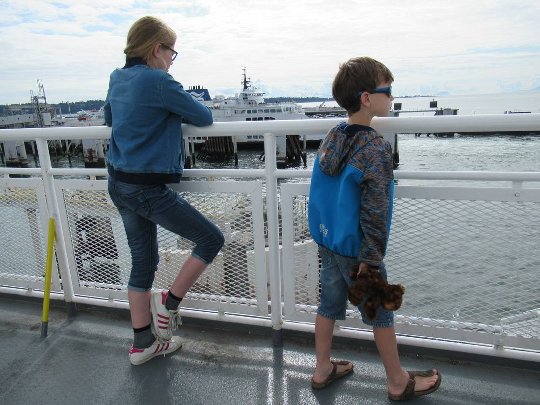 Twee kinderen aan de reling van de veerboot naar Vancouver Island, British Columbia, West-Canada