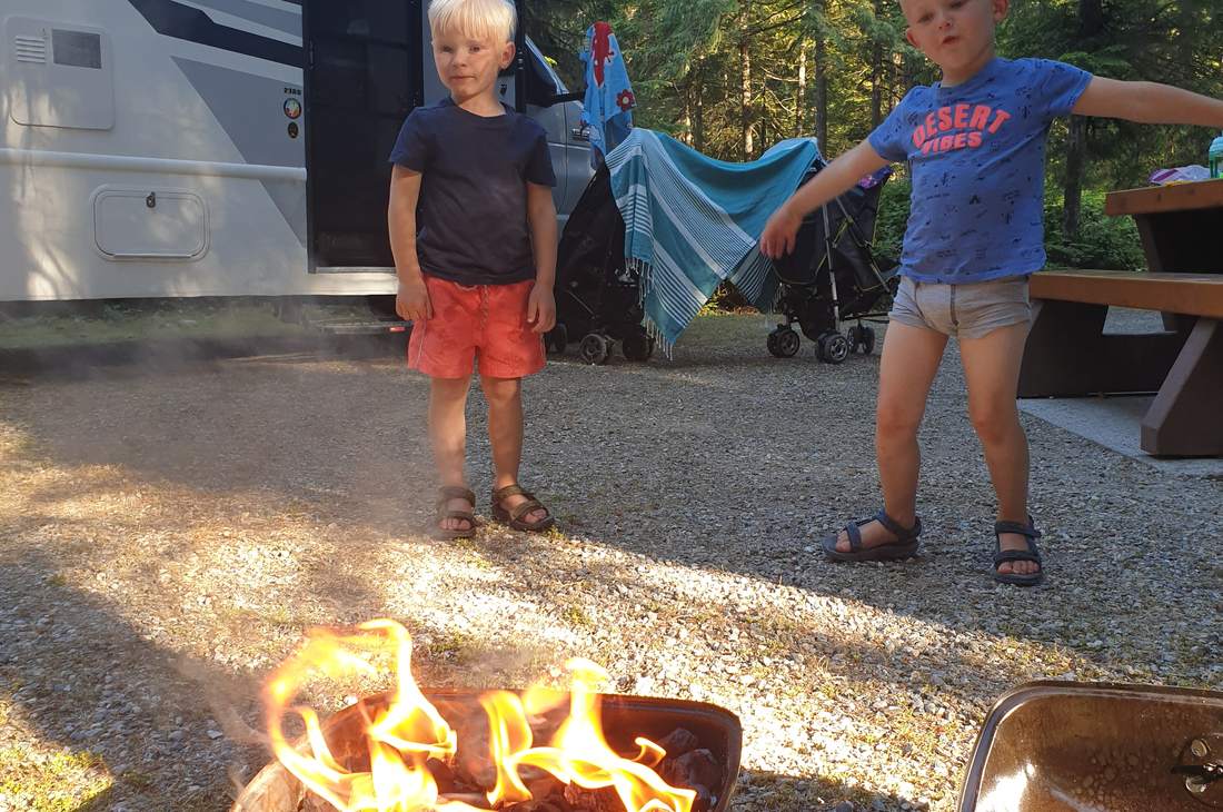 Kinderen bij het kampvuur naast de camper, West-Canada