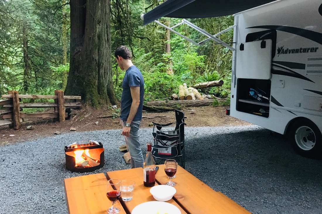 Koken op het vuur naast de camper op een boscamping, West-Canada