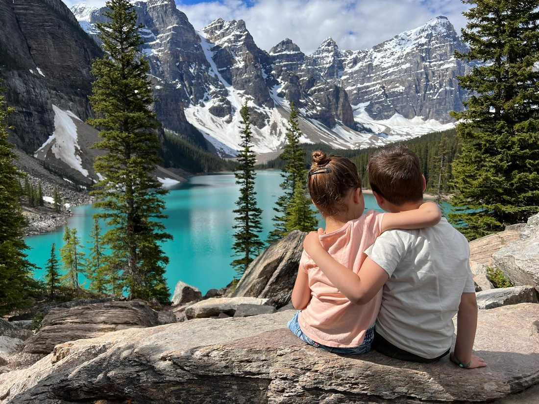 Twee kinderen arm in arm boven Moraine Lake bij Banff, Alberta, West-Canada