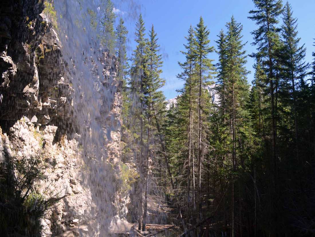 Achter deze waterval kun je langslopen.