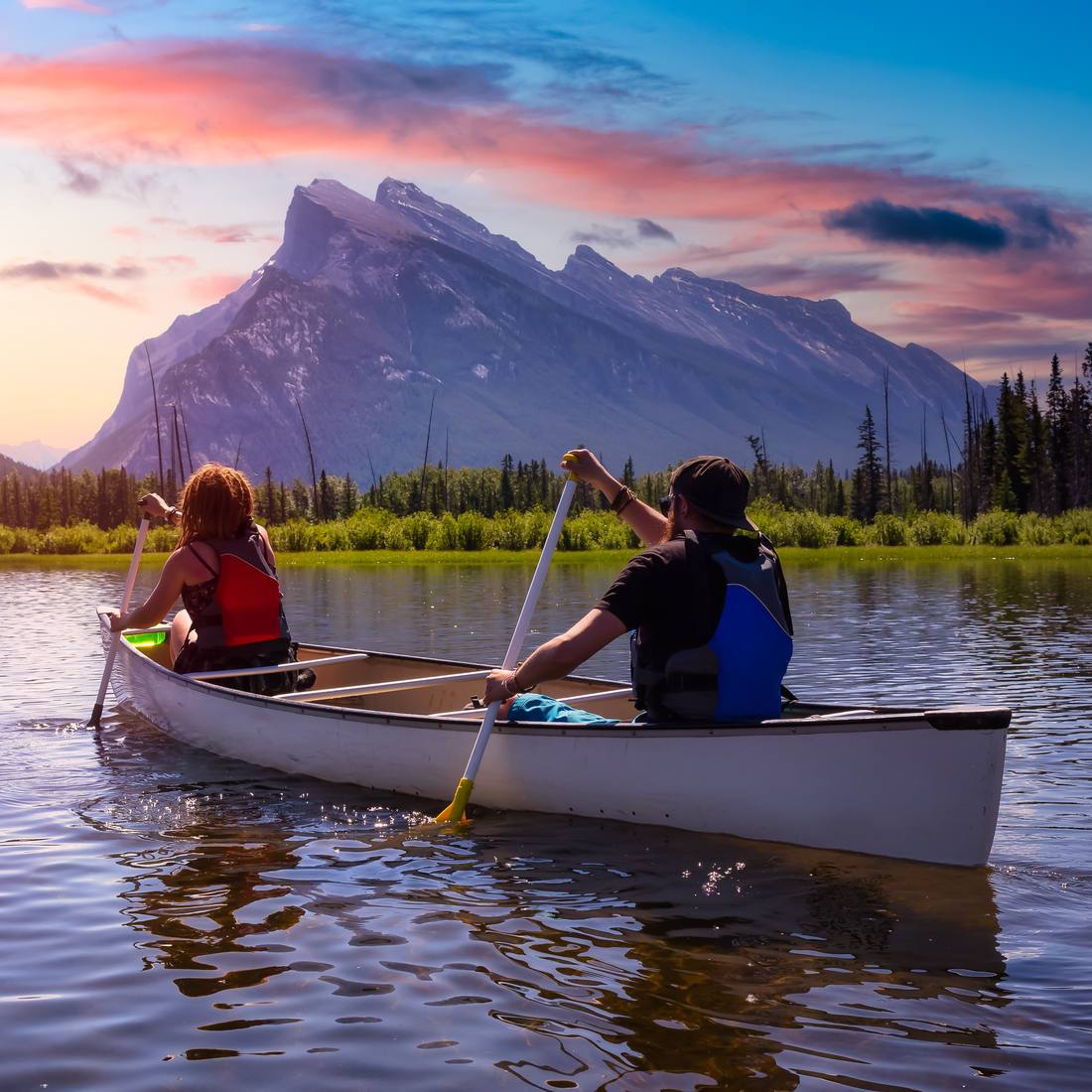Een stel in een kano op Vermilion Lakes bij zonsondergang, met Mount Rundle erachter, Banff, Alberta, West-Canada