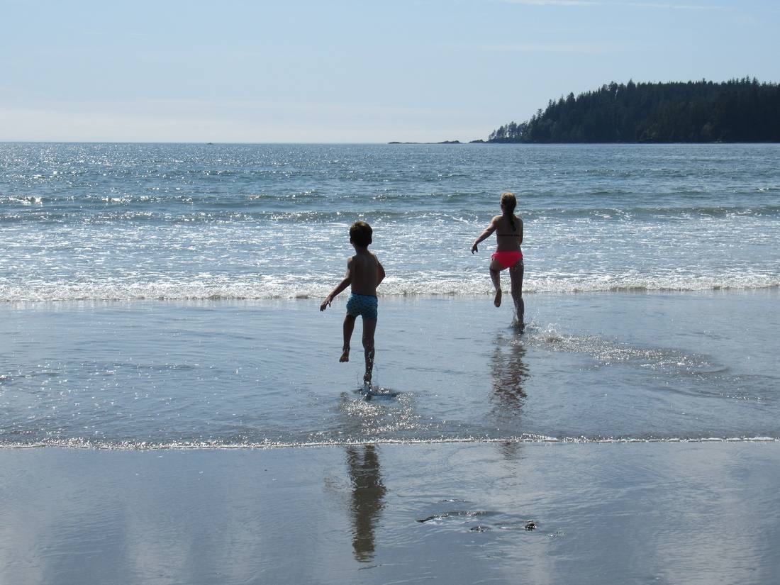 Twee kinderen rennen de zee in, Vancouver Island, British Columbia, West-Canada