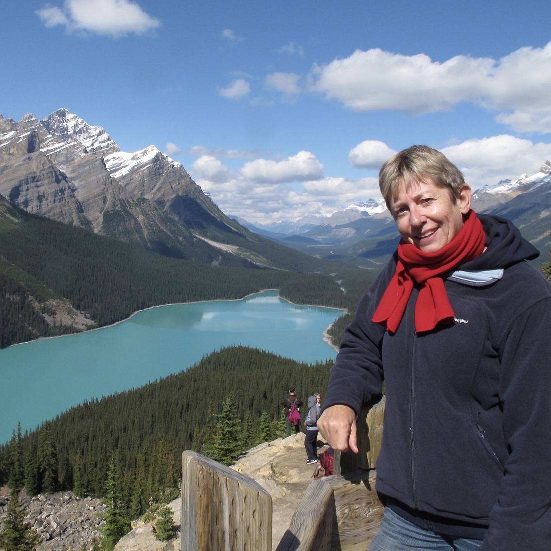 Een vrouw met een rode sjaal boven het turquoise Peyto Lake, vlak bij Lake Louise, Alberta, West-Canada