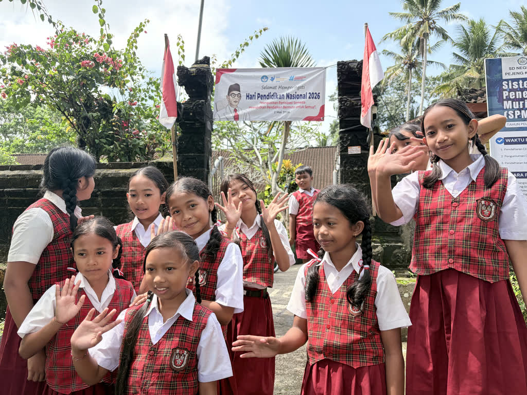 Balinese schoolkinderen zwaaien tijdens een gezinsreis door Indonesië