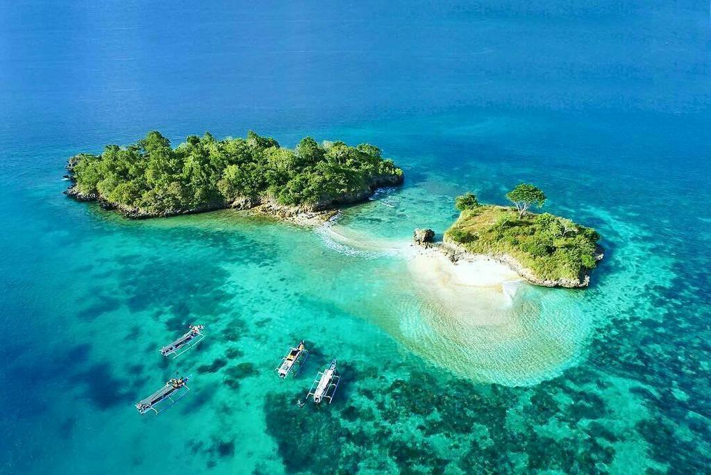 Een klein eiland met helder water eromheen, van boven gezien, Indonesië