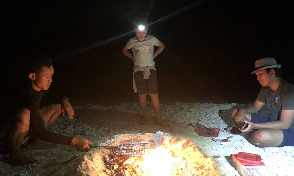 Kampvuur op het strand in het donker, Indonesië