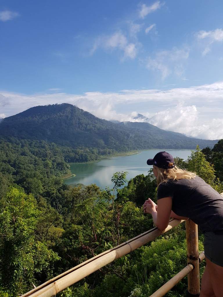 Reiziger kijkt vanaf een bamboe balkon uit over het kratermeer, Indonesië