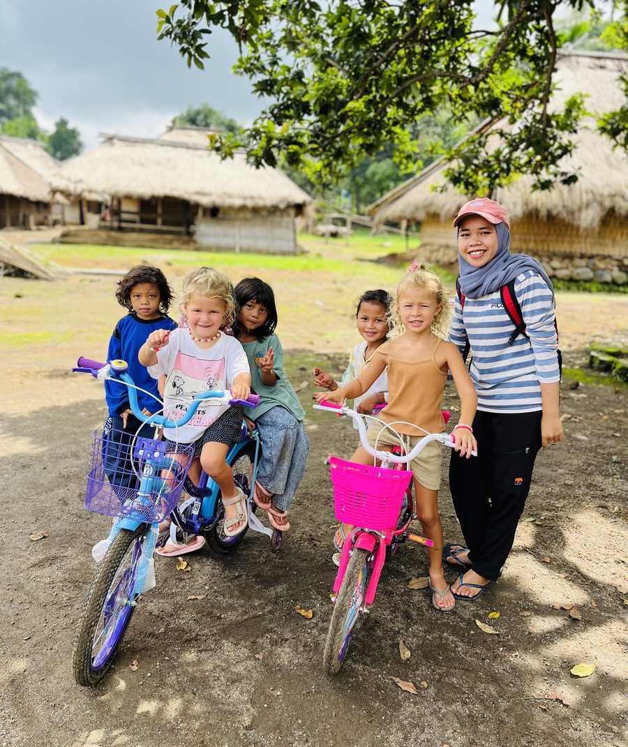 Kinderen op de fiets in een dorp bij Senaru op Lombok, Indonesië