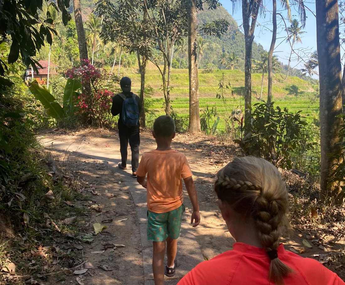 Achter de gids aan over het pad naar de waterval bij Munduk, Bali, Indonesië