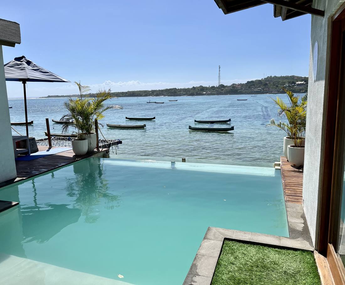 Het zwembad ligt vlak aan zee met de vissersboten ervoor op Nusa Lembongan, Indonesië
