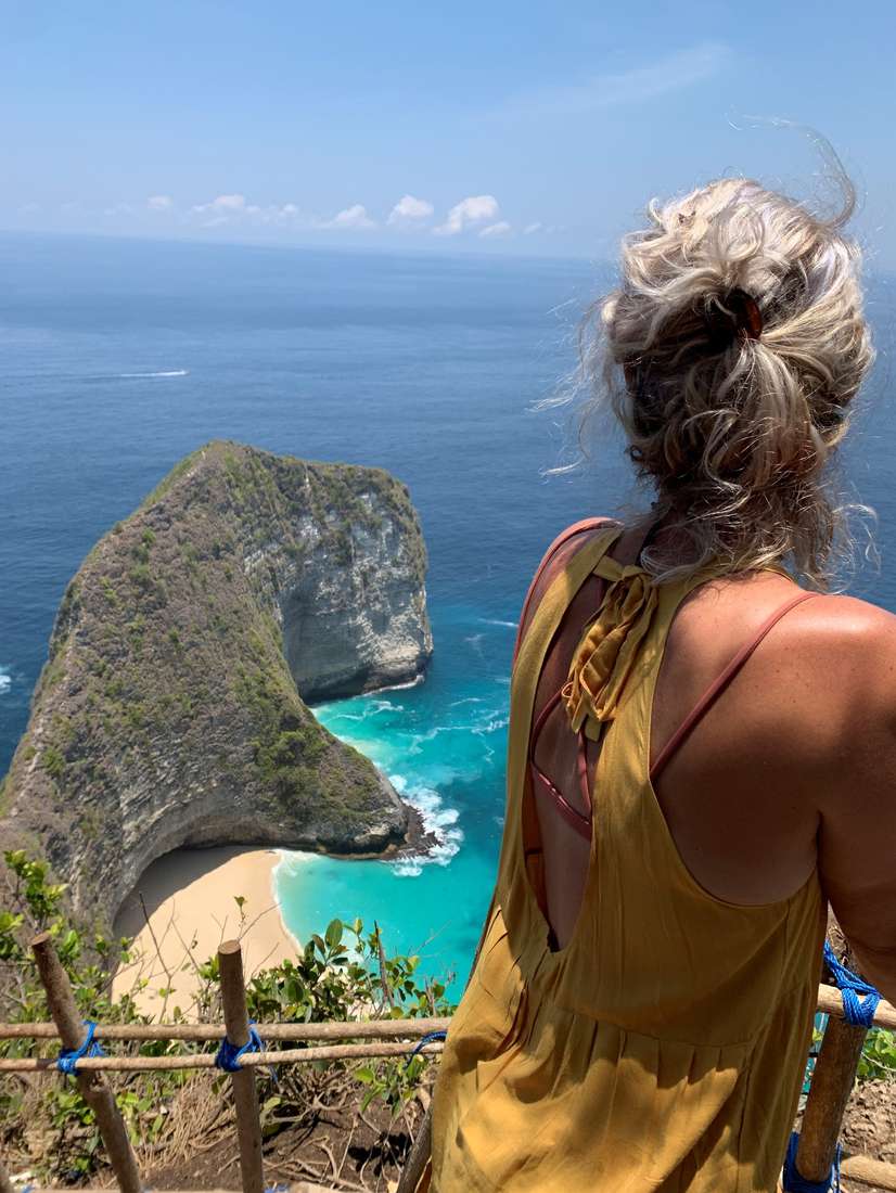 Reiziger kijkt uit over de kliffen en de baai van Nusa Penida bij Bali, Indonesië