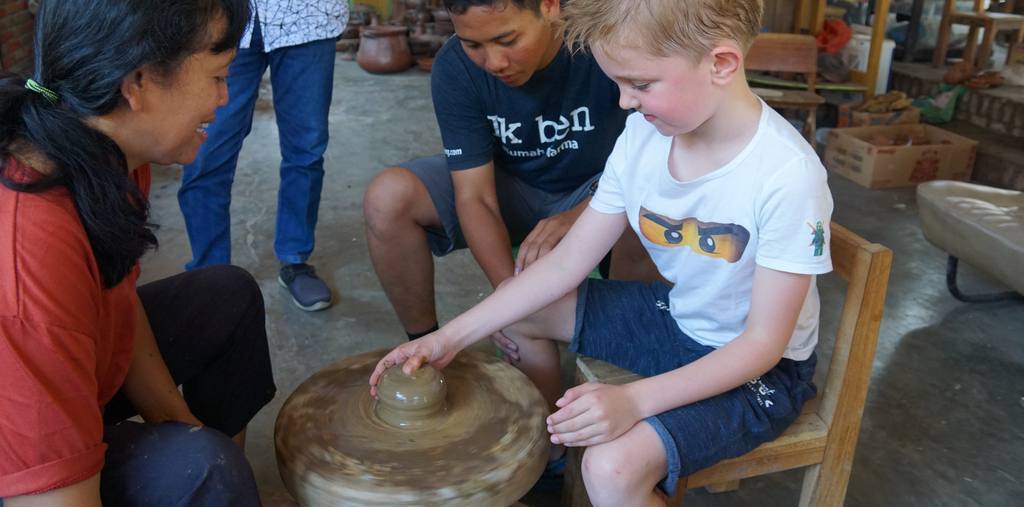 Kind leert pottenbakken van een Javaanse pottenbakster, Indonesië