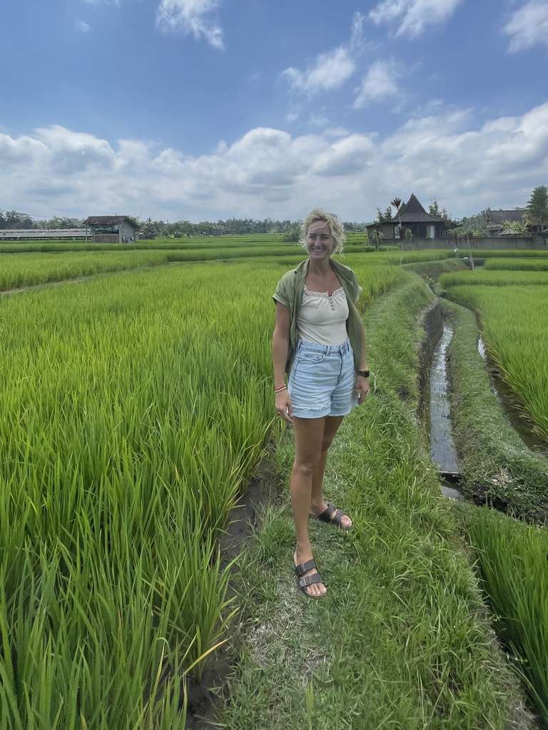 Reiziger loopt over een smal pad door de rijstvelden op Bali, Indonesië