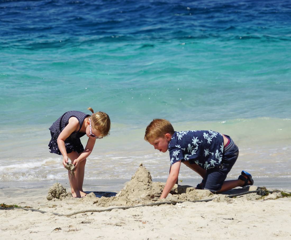 Twee jongens bouwen een zandkasteel op het strand, Bali, Indonesië