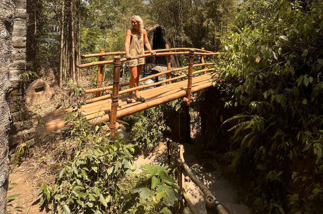 Reiziger op een bamboe brug door de jungle bij Ubud, Bali, Indonesië