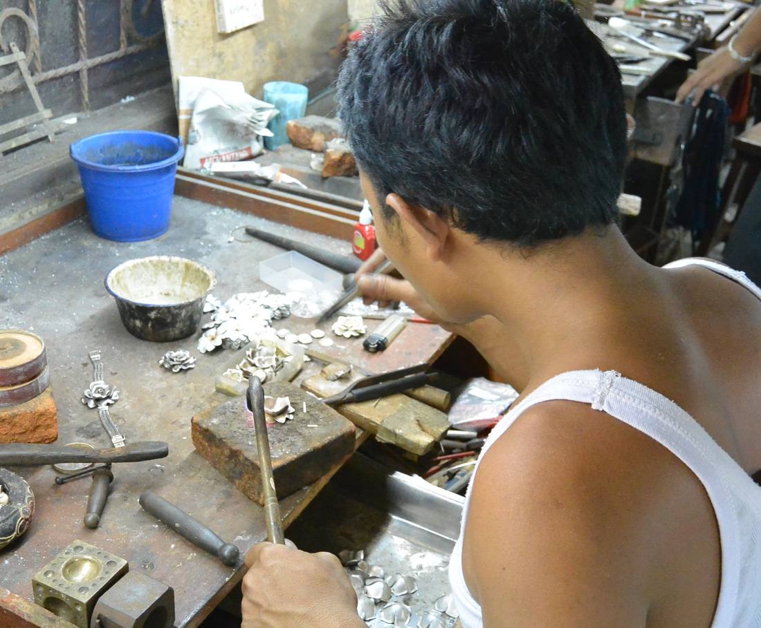 Een zilversmid werkt aan een sieraad in zijn werkplaats bij Ubud, Bali
