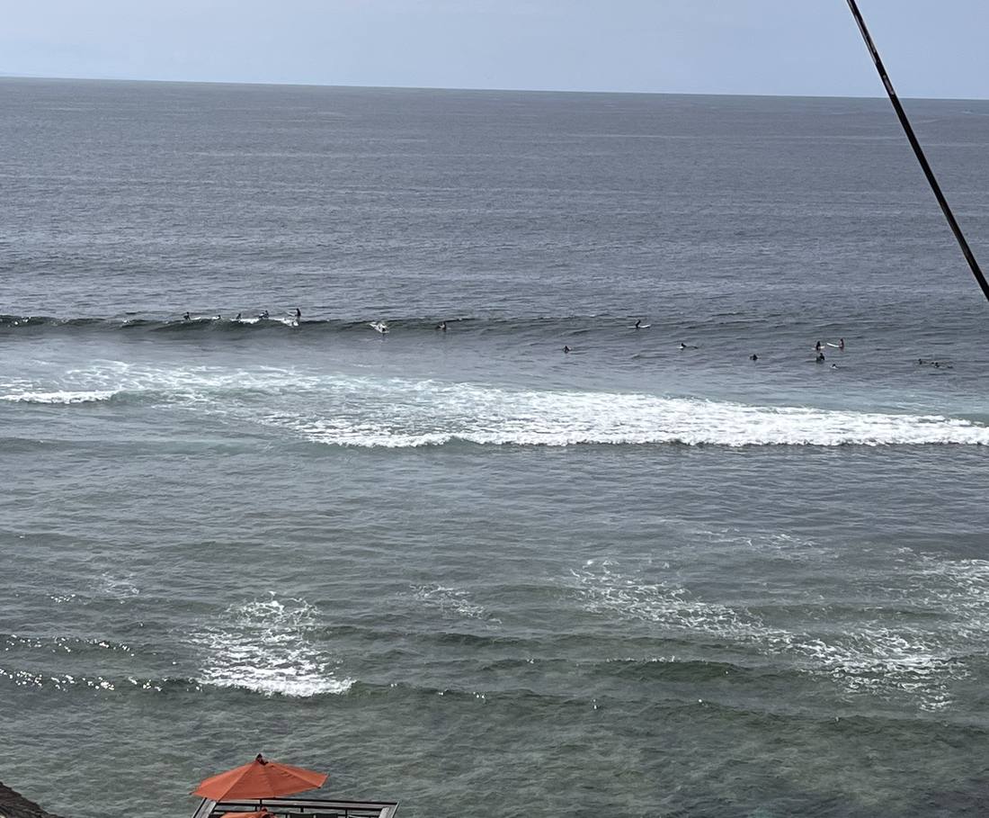 Surfers liggen te wachten op de golven voor de kust van Uluwatu, Bali