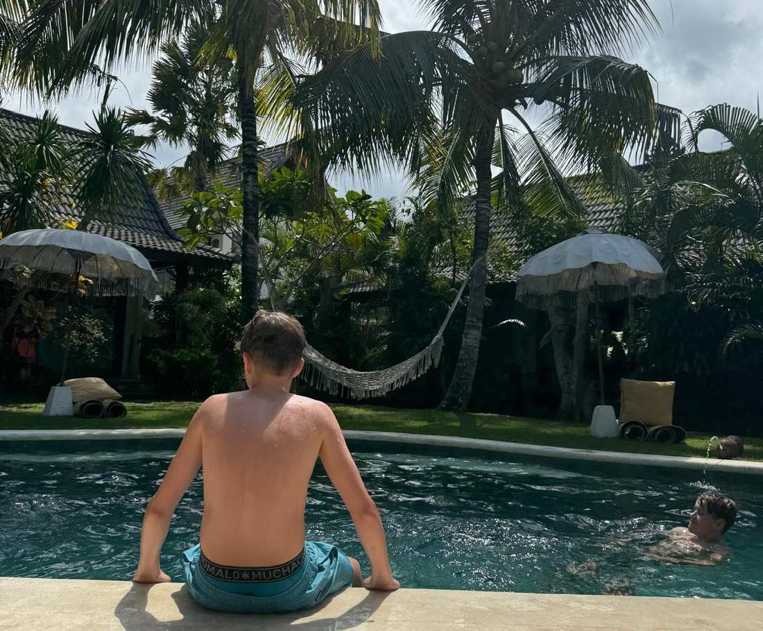 Het zwembad ligt tussen de palmen bij een kleinschalig hotel in Uluwatu, Bali