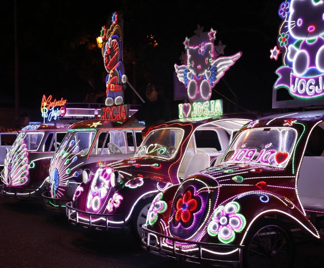 Skelters vol neonlichtjes staan 's avonds klaar op het Alun-Alun Selatan in Yogyakarta, Indonesië