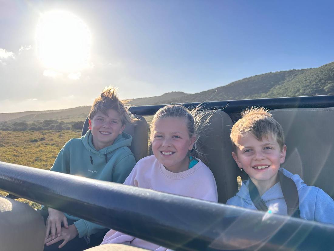 De drie kinderen in de open safariwagen, Zuid-Afrika