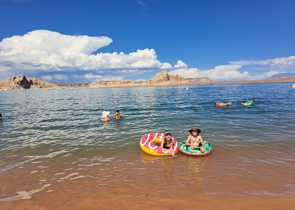 De kinderen dobberen op zwembanden in Lake Powell, Amerika