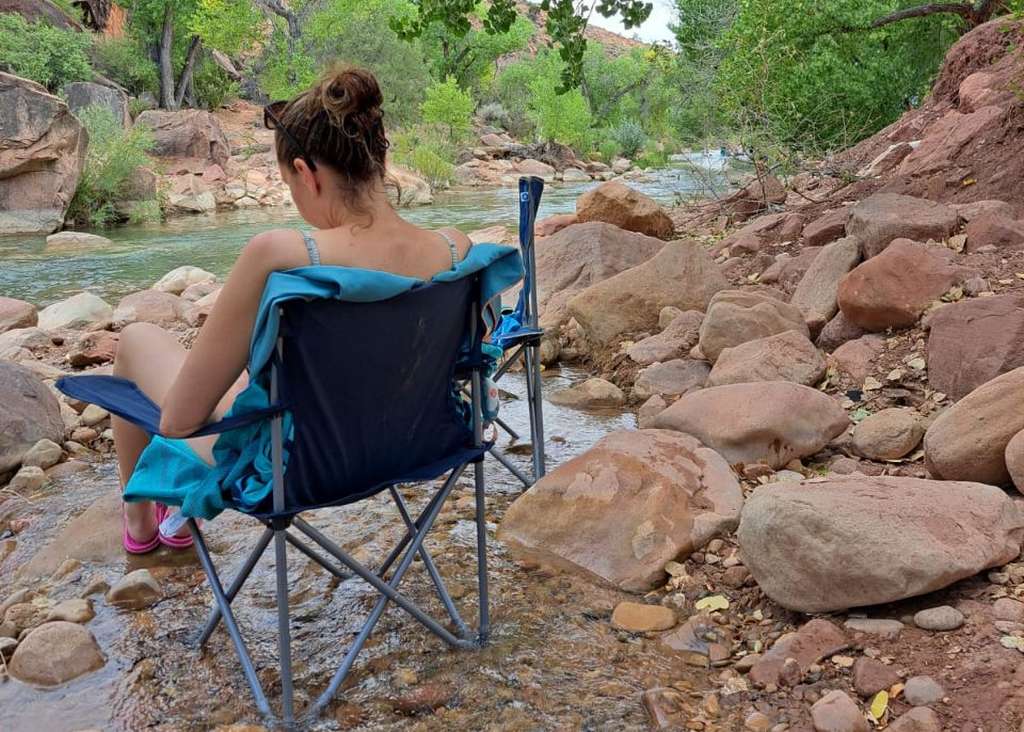 Met een kampeerstoel in het riviertje in Zion National Park, Utah, Amerika