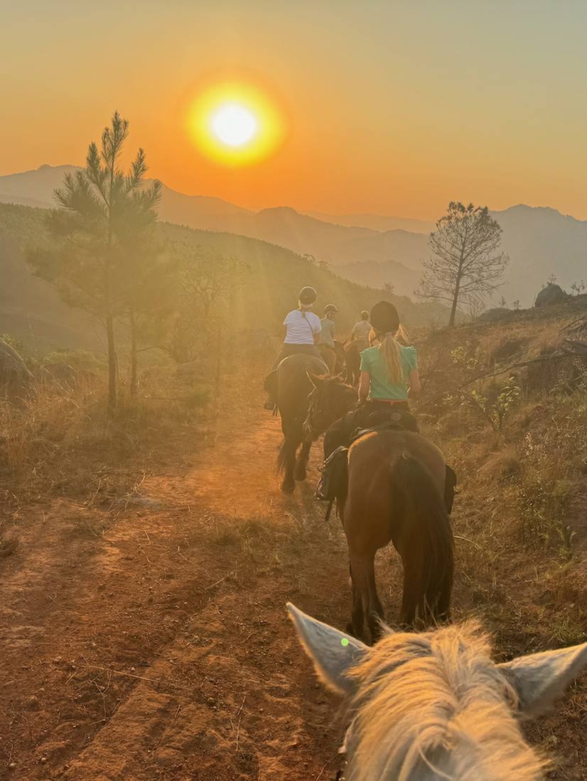 Te paard over een bergpad in het laatste licht, Zuid-Afrika