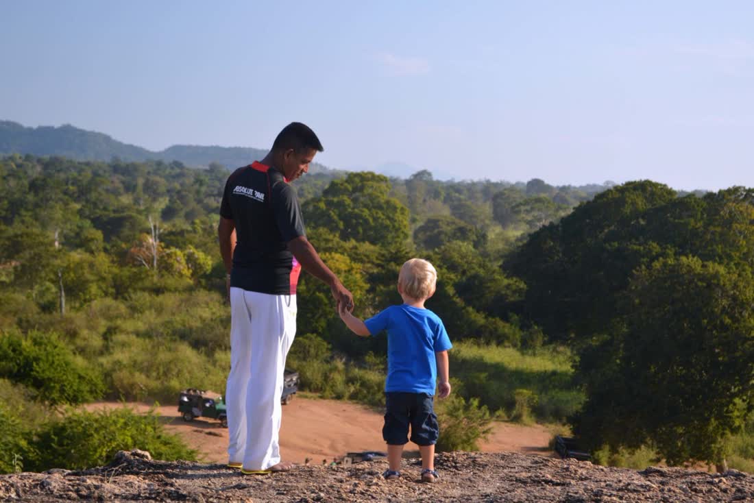Chauffeur en peuter kijken samen uit over de jungle, Sri Lanka